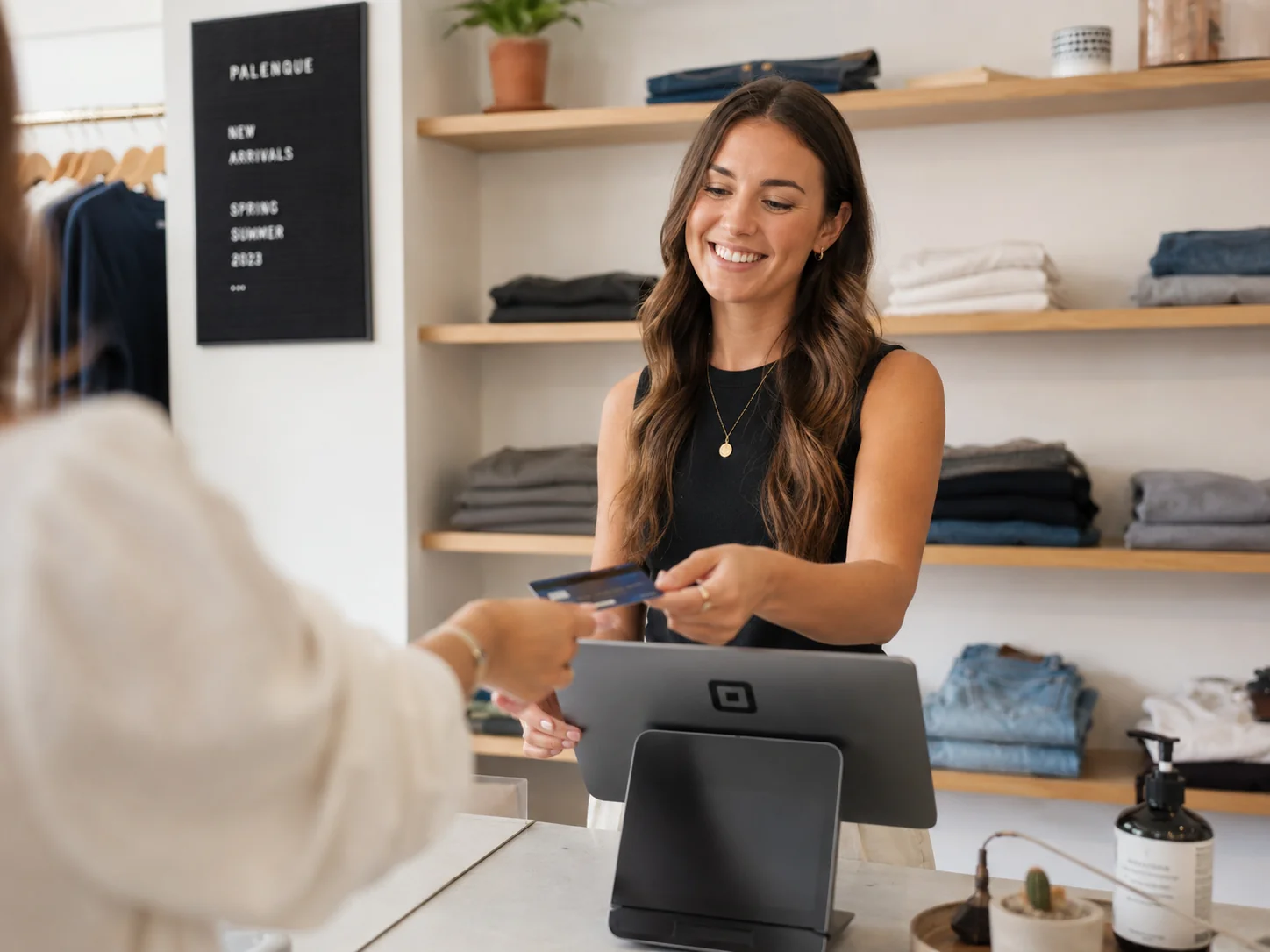 Cashier processing card payment at a clothing boutique